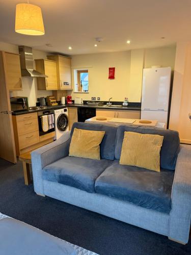 a living room with a blue couch in a kitchen at Quirky and spacious in Lawley Bank