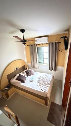 a bedroom with a bed in a room with a window at HOTEL LAREIRA in São José dos Campos