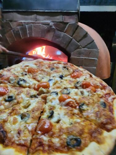 a pizza is in front of a brick oven at Casa Ya Thip in Ban Huai Ti