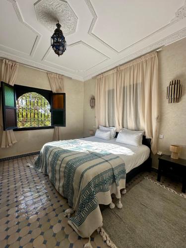a bedroom with a bed and a chandelier at Villa Atika in El Bougaria