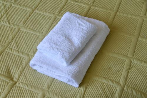 One Bedroom Apartment Next to Arbat In The Center of Almaty في ألماتي: منشفة بيضاء موضوعة فوق السرير