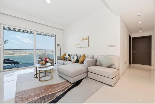 a living room with a couch and a table at Luxury 2BR Emaar Beachfront with Private Beach & Infinity Pool, Palm Jumeirah & Atlantis Views in Dubai