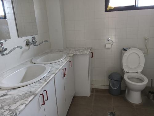 a bathroom with two sinks and a toilet in it at צימר טיילת הכלנית in Ma'alot Tarshiha