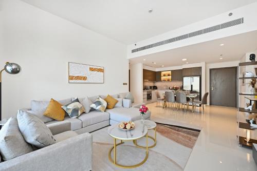 a living room with a couch and a table at Luxury 2BR Emaar Beachfront with Private Beach & Infinity Pool, Palm Jumeirah & Atlantis Views in Dubai