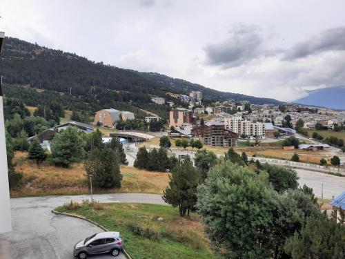 a car parked in a parking lot in a city at Nid des Angles - Cœur de station vue Lac & Montagne in Les Angles