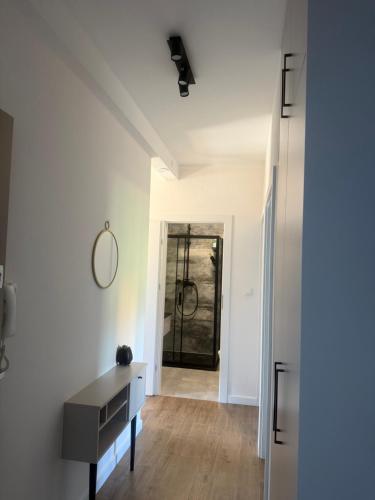 een witte kamer met een bureau en een spiegel bij Apartament Od Nowa Zdrój in Busko-Zdrój