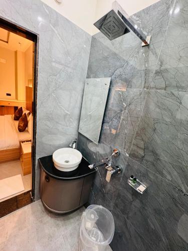 a bathroom with a sink and a toilet and a mirror at Hotel RS Grand in Kashi