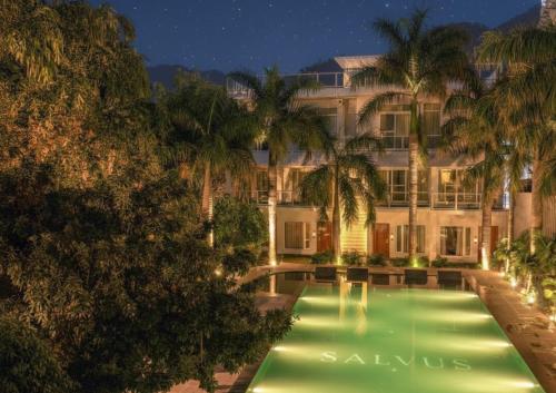 een hotel met een zwembad in de nacht bij Narayana Sanctuary Resort by SALVUS in Rishīkesh