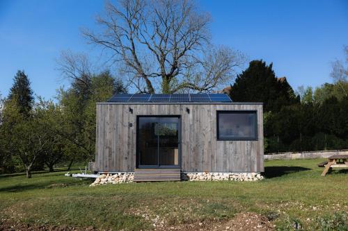 a tiny house with solar panels on a field at Parcel Tiny House Vallée, près de Verdun in Rarécourt