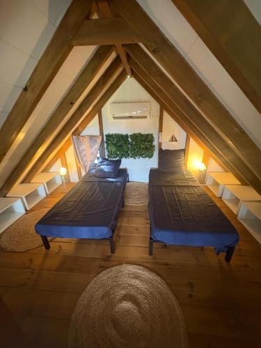 a attic room with two beds and a rug at Chill lodge in Sainte-Luce