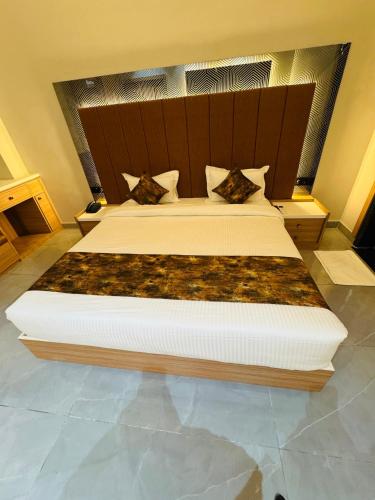 a bedroom with a large bed with a wooden headboard at Hotel RS Grand in Kashi
