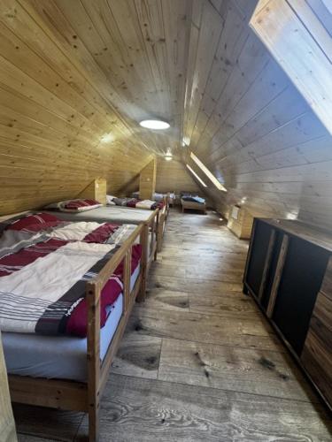 a group of beds in a room with a long hallway at Chata Pavlínka samota pri lese in Chvojnica