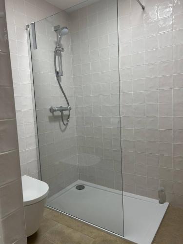eine Dusche mit Glastür und ein WC in der Unterkunft Stylish One Bedroom Apartment in Central Potton in Potton