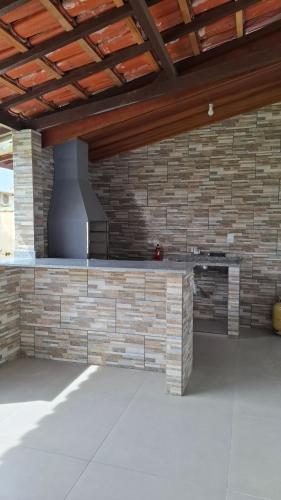 a kitchen with a brick wall and a stove at Casa Verão Cananéia in Cananéia