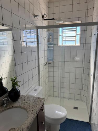 a bathroom with a toilet and a sink and a shower at Apartamento perto do centro da Cidade in Campo Grande