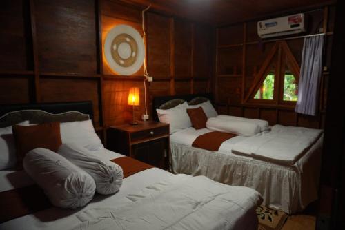 une petite chambre avec deux lits et une fenêtre dans l'établissement Villa Ilham Ketembong, à Tetebatu