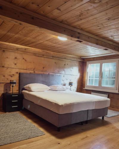 レンクにあるFerienwohnung Metschの木製天井のベッドルーム1室(大型ベッド1台付)