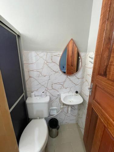a bathroom with a toilet and a sink and a mirror at Apartamento aconchegante in Belém
