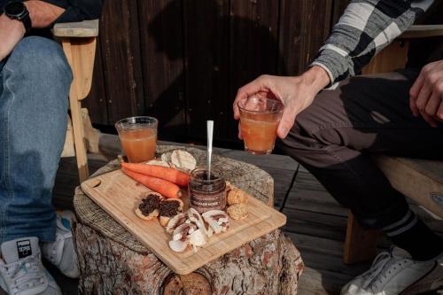 a person holding a drink on a table with a tray of food at Parcel Tiny House Regagnas- au pied de la Sainte Victoire in Trets