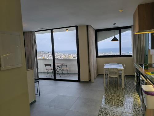 Una cocina con una mesa y algunas sillas y ventanas. en YaYaCaSa, en Tánger