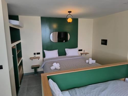 Un dormitorio con dos camas y una pared verde. en YaYaCaSa, en Tánger