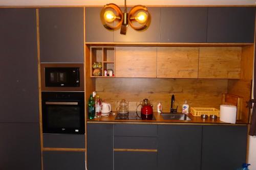 una cucina con lavello e microonde di Chez Vila a Prizren
