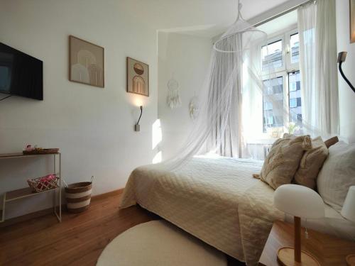 a white bedroom with a bed and a window at Cozy small apartment in Vienna