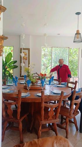 a man standing at a wooden table in a room at Hotel Casa la Gregorienne in La Vega