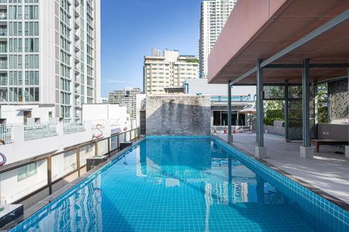 a swimming pool on the roof of a building at Dazzle Residence ByPinny in Bangkok