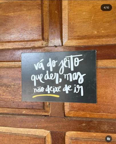 a sign on a wooden door with writing on it at Recanto Monte das Oliveiras Hotel e Pousada in Tupim