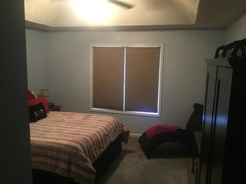 a bedroom with a bed and a window with blinds at Captivating Home near Downtown ATL in Conley