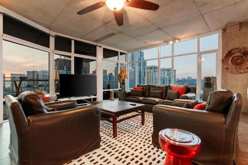 un soggiorno con mobili in pelle e una TV a schermo piatto di The Gallery Loft - Downtown finest a San Diego