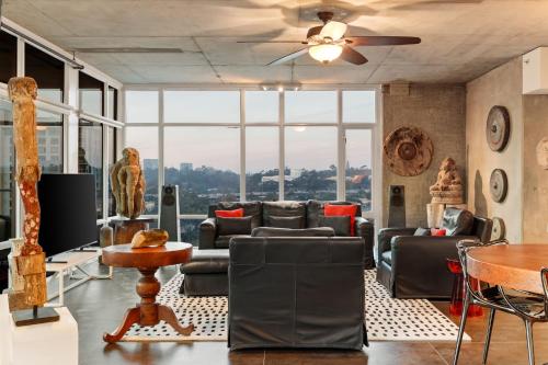 a living room with couches and a ceiling fan at The Gallery Loft - Downtown finest in San Diego