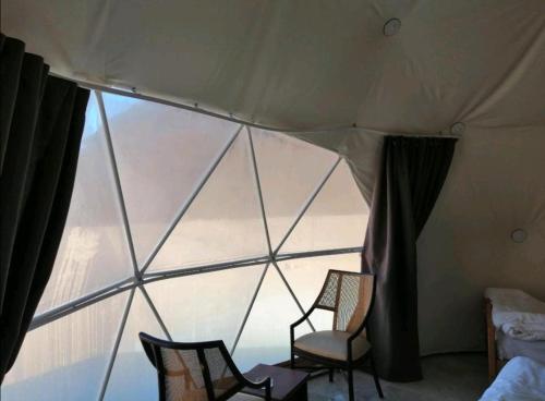 Disahにあるmountains wadi rumの大きな窓のある部屋に椅子が2脚ある