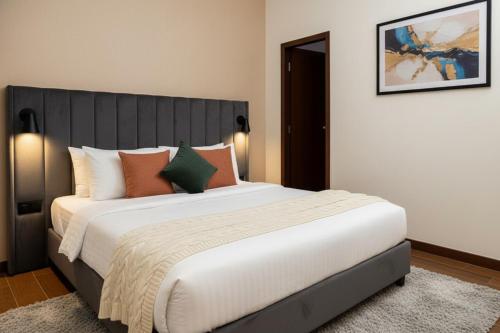 a bedroom with a large white bed with orange pillows at Hotel Grand Stay Park Near Ameerpet Metro Station & GVK One Mall in Hyderabad