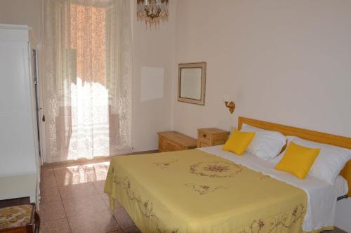 una camera da letto con un letto con cuscini gialli e una finestra di Casa Ciri Bed & Breakfast a Foligno