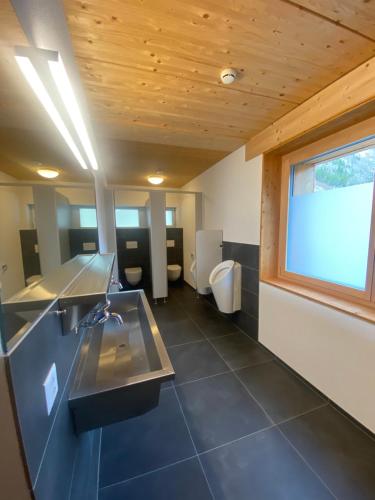 un ampio bagno con due servizi igienici e una finestra di Gadmer Lodge - dein Zuhause in den Bergen a Gadmen