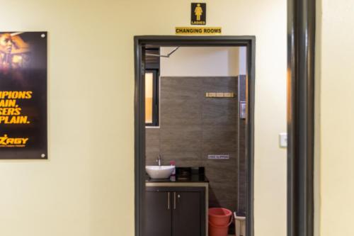 a bathroom with a mirror and a sink at Riverside Suites Buwate in Kampala