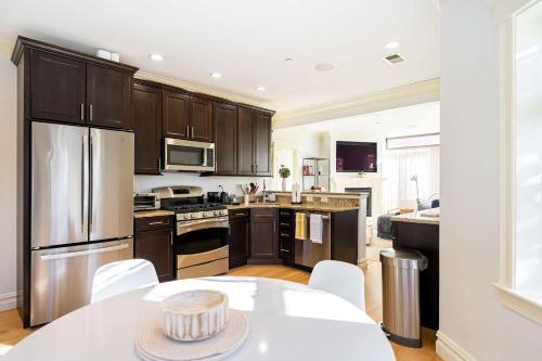 a kitchen with stainless steel appliances and a table at Brownstone Luxury Penthouse Condo in Boston