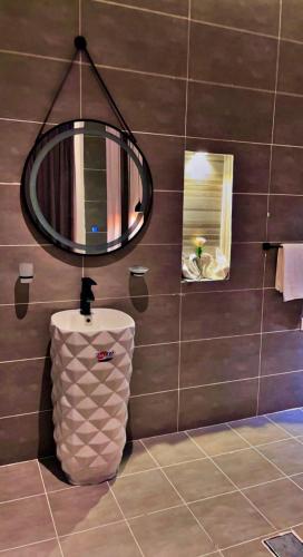a bathroom with a toilet and a round mirror at شاليهات سمو بارك 1 in Taif