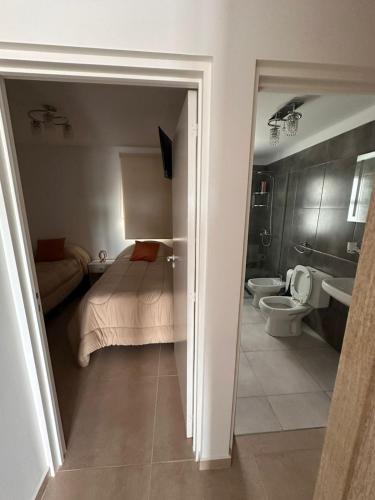 a bedroom with a bed and a bathroom with a toilet at urbano in Neuquén