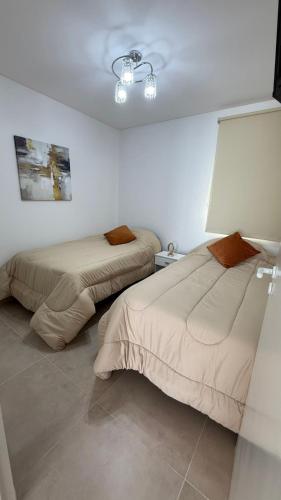 a bedroom with two beds and a lamp in it at urbano in Neuquén