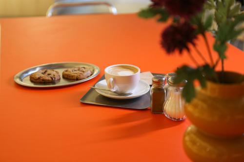 Una mesa con un plato de galletas y una taza de café. en Mustard Hostel, en Dijon