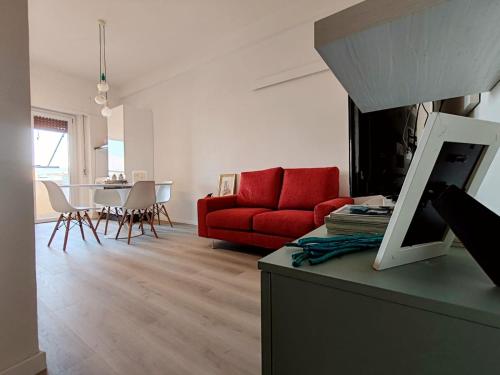 a living room with a red couch and a table at La Casa Vacanze di Grace in Follonica