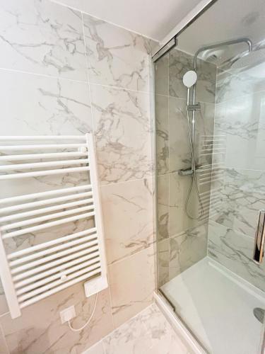 a bathroom with a shower with marble tiles at Le Cocon Mévennais in Saint-Méen-le-Grand