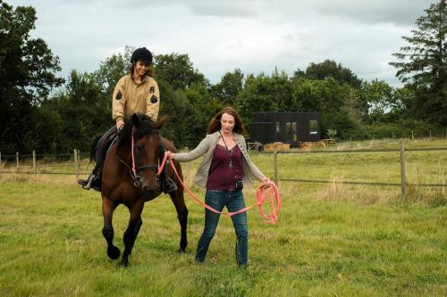 a man and a woman standing next to a horse at Parcel Tiny House Mainteloup dans le perche Normand in Bretoncelles