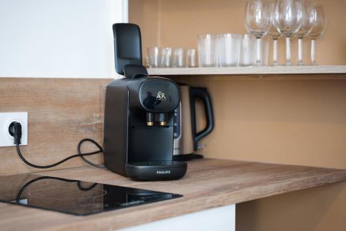 a black coffee maker sitting on a counter with glasses at bel appartement 2-4 personnes coeur de ville Angers in Angers