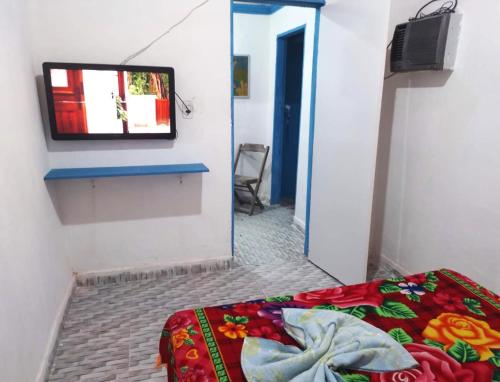 a room with a bed and a tv on a wall at Vila Sol & Mar Gaibu PE in Cabo de Santo Agostinho