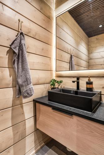 a bathroom with a black sink and a mirror at LeviLakeVillas B in Levi