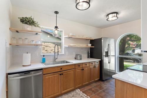 a kitchen with a sink and a refrigerator at May Specials - Private Pool, Family Friendly! in The Colony